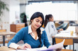 © Sam Edwards/Caia Image - Businesswoman reviewing paperwork in office