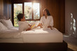 © Tom Merton/Caia Image - Couple in bathrobes relaxing on hotel bed