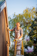 © Tom Merton/Caia Image - Portrait confident male painter on ladder painting home exterior
