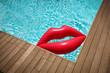© Tom Merton/Caia Image - Inflatable lips floating in sunny summer swimming pool