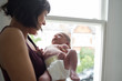 © Sam Edwards/Caia Image - Mother holding cute newborn baby boy at window