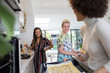 © Sam Edwards/Caia Image - Happy young women friends cooking in kitchen