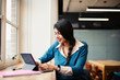 © Sam Edwards/Caia Image - Businesswoman working at digital tablet in office