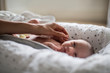 © Sam Edwards/Caia Image - Mother touching innocent newborn baby boy in bassinet