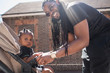 © Sam Edwards/Caia Image - Portrait happy father with long braids fastening toddler son in stroller