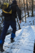 Hiker Crossing Snow Covered Bridge