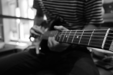 Blured Photo of young musician playing Electric Guitar, play the music instruments, black and white tone