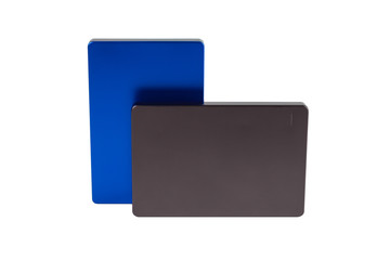 Two gray and blue external hard drives lying on top of each other on a white isolated background