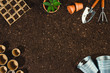 Gardening tools on soil texture background top view.