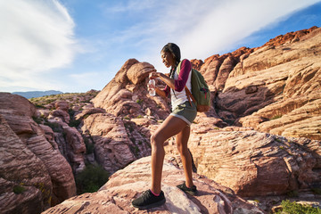 Wall Mural - female hiker with water bottle looking at landscape at red rock canyon