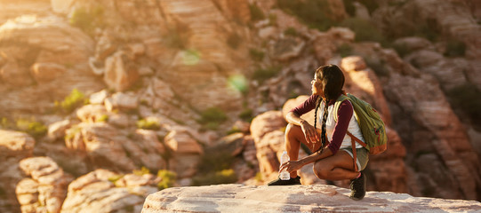 Wall Mural - athletic african american woman backpacker on top of tall cliff at red rock canyon nevada