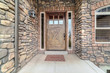 Entrance door to home with stone brick walls