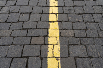 dividing yellow stripe on gray old paving stones