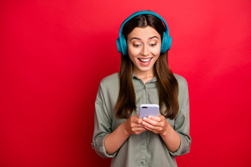 Poster - Close-up portrait of her she nice attractive lovely glad cheerful cheery straight-haired girl in khaki shirt choosing listening track hit isolated on bright vivid shine vibrant red color background