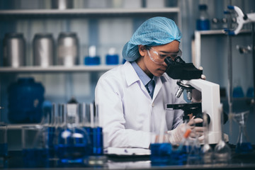 Wall Mural - young scientist working with a microscope in a laboratory. young scientist doing some research.