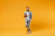 © ViDi Studio - Smiling young student man in casual blue shirt posing isolated on yellow orange wall background studio portrait. People sincere emotions lifestyle concept. Mock up copy space. Holding red notebook.