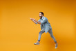 © ViDi Studio - Excited young bearded man in casual blue shirt posing isolated on yellow orange background studio portrait. People emotions lifestyle concept. Mock up copy space. Jumping pointing index fingers aside.