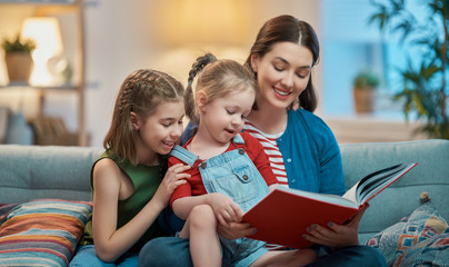 Wall Mural - mother reading a book to daughters