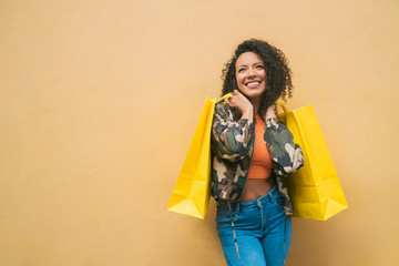 Afro american latin woman holding shopping bags.