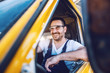 © Dusan Petkovic - Smiling handsome unshaven worker driving vehicle on construction site.