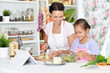 © aletia2011 - Cute little girl with her mother cooking together at kitchen table