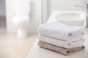 Canvas Print - Stack of fresh towels on countertop in bathroom. Space for text