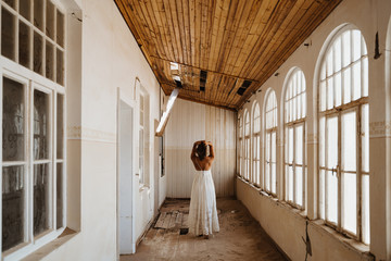 Poster - bride after getting ready standing in an abandoned old building