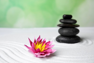 Zen garden. Beautiful lotus flower and stones on white sand