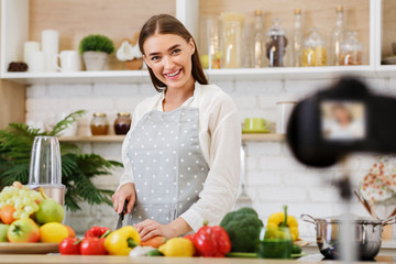 Food blogger concept. Happy woman recording video on camera