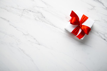 Wall Mural - white gifts with red ribbon, present on white marble background top view. happy holidays. valentine'