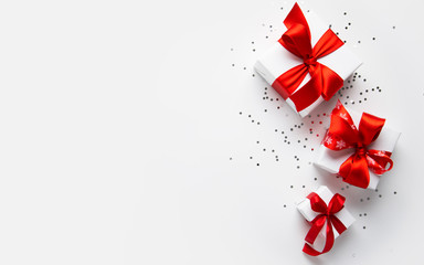 Wall Mural - white gifts with red ribbon, present on white background top view. happy holidays. valentine's day. 