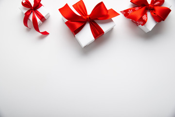 Wall Mural - white gifts with red ribbon, present on white background top view. happy holidays. valentine's day. 