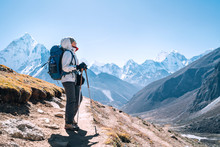 Young Hiker Backpacker Female Taking A Walking With Trekking Poles During High Altitude Everest Base Camp Route Near Dingboche,Nepal. Ama Dablam 6812m On Background. Active Vacations Concept