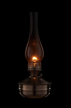 Vintage Kerosene Lamp Burning On Black Background. Glass Old Oil Lamp.