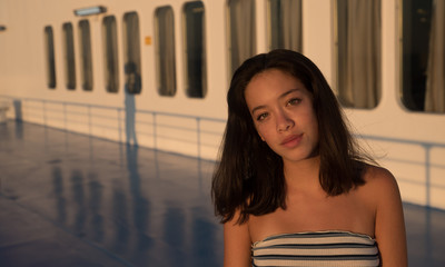 Wall Mural - Closeup of Asian teen on in tube top on Ferry boat with windows in the background