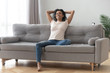 © fizkes - Serene smiling african woman resting on couch at home