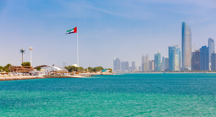 Wall Mural - Skyline view of Abu Dhabi panorama with sea, beach and skyscrapers. Sunny summer day in Abu Dhabi - famous tourist destination in UAE. Ideal place for luxury travel and rest