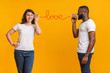 © Prostock-studio - Romantic multiracial couple talking sweet through tin phone