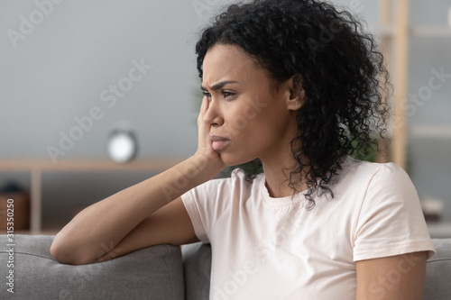 Cuadros en Lienzo Side closeup view african sad pensive woman sitting on couch