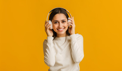 Portrait of happy girl listening her favorite music in wireless headphones