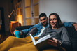 © cherryandbees - romantic couple laying sofa in their living room reading book