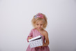 © Olesya Pogosskaya - cute little girl in a princess dress with a crown holding a gift on a white background