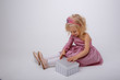© Olesya Pogosskaya - a blonde girl with a gift in a Princess dress sits on a white background