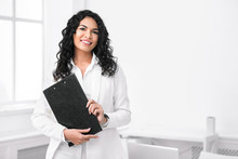 Portrait Of Mexican Woman With Clipboard At Office