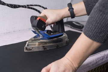 seamstress master, in the sewing salon, using the iron, the master irones the clothes