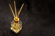 Fragrance diffuser in glass bottle with reeds on slate background.