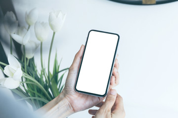 Mockup image blank white screen cell phone.man hand holding texting using mobile sitting at coffee shop.background empty space for advertise text.people contact marketing business,technology 