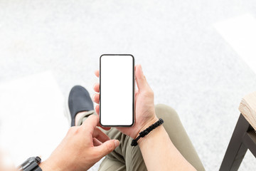 Mockup image blank white screen cell phone.man hand holding texting using mobile sitting at coffee shop.background empty space for advertise text.people contact marketing business,technology 