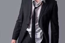 Portrait Of A Business Man, In An Untidy Business Suit, Wrinkled Clothes, Sloppy Look. On A Gray Background