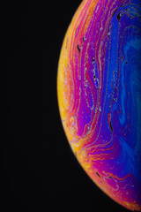 Wall Mural - close up macro photograph of the psychedelic rainbow of colors mixing and swirling in a soap bubble 